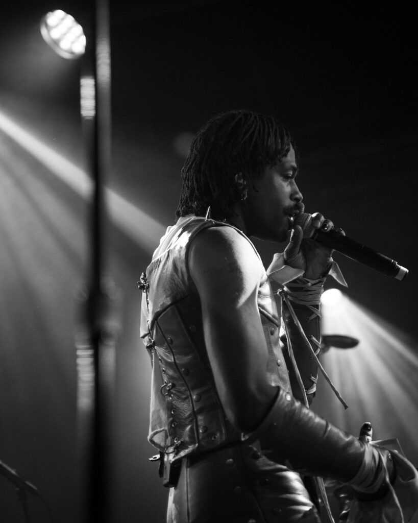 Duckwrth singing into the microphone during a live set at Treefort Music Hall