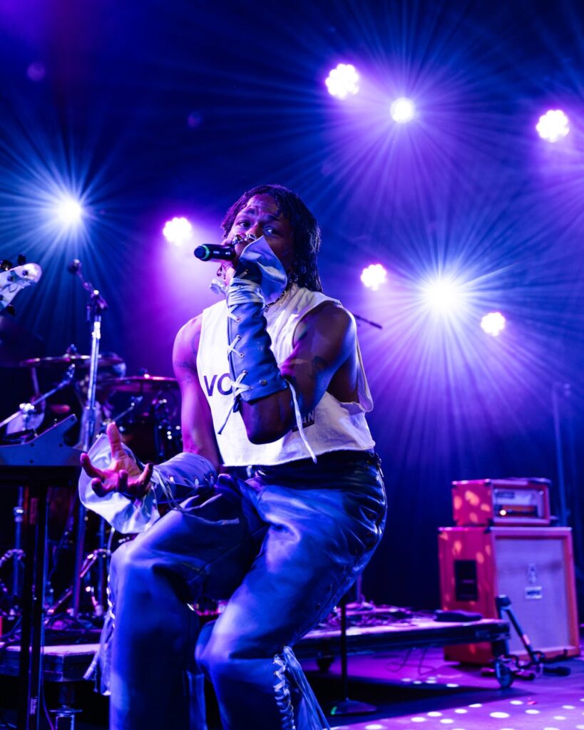 Duckwrth lit from behind by stage lights during a live show at Treefort Music Hall