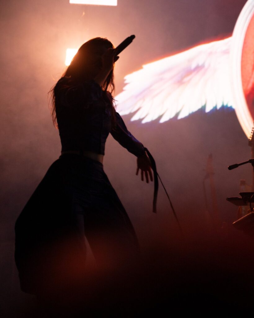 Vocalist silhouetted against a winged stage backdrop at Treefort Music Hall